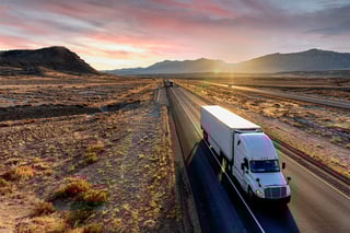 truck driving on highway at sunset