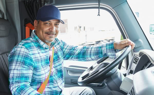 smiling-latino-truck-driver-behind-wheel